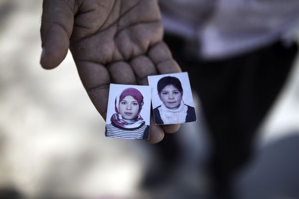 Atmatzan, a 42 years old refugee from Afghanistan that have arrived to Greece with his wife and two younger children shows the pictures of his two older daughters that they had to be left behind at home with their grandparents. Menelaos Myrillas / SOOC