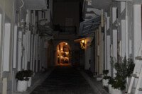 Η καμάρα του “Καραουλάνη” φωτισμένη, λιγοστό φως και κυριαρχία του λευκού.